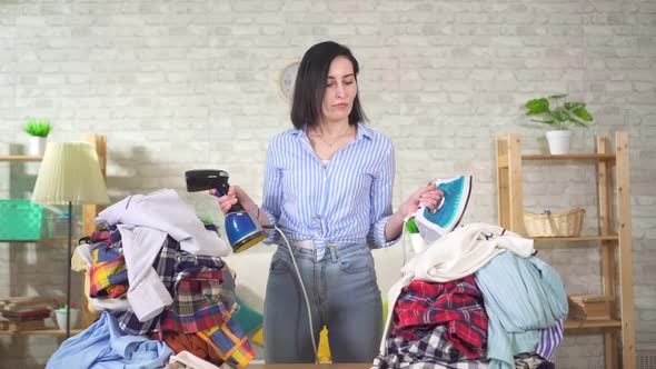 Young Housewife Chooses Between Iron Steamer Ironing Clothes