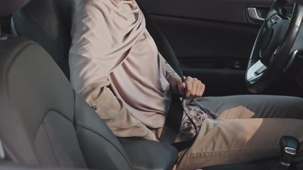 Woman in Hijab Putting Seat Belt On before Driving Car