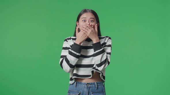 Asian Woman Surprised While Standing In Front Of Green Screen Background