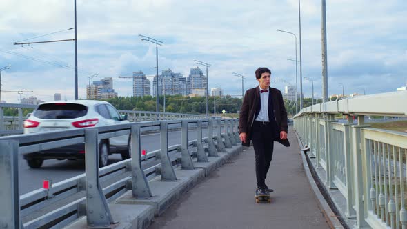 Skateboarder Rides on Skateboard on City Bridge