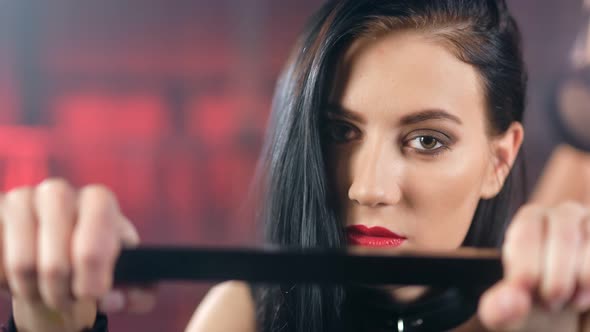 Closeup of Sexy Brunette Vamp Girl Feeling Pain During Bdsm Punishment Looking at Camera