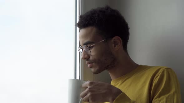 At the Window a Young Man with a Mug