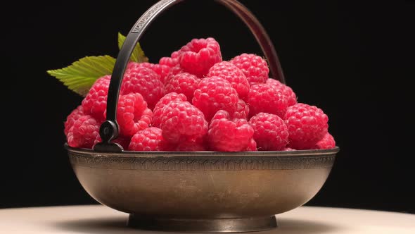 Ripe Raspberries in Vintage Metal Bowl Rotation on Black Background