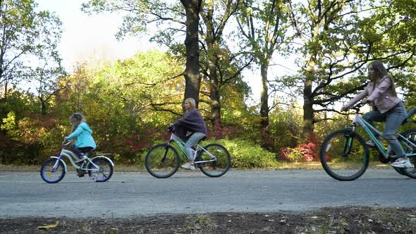 Family of five on cycle ride in park