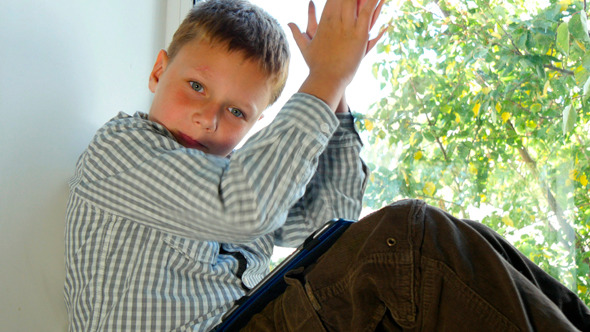 Boy Sitting By A Window Using His Tablet 5