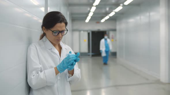 Sick Female Doctor Coughing in Safety Mask Standing in Hospital Hallway