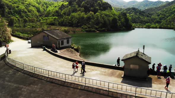 Aerial View a Dam with Green Mountains and Some People