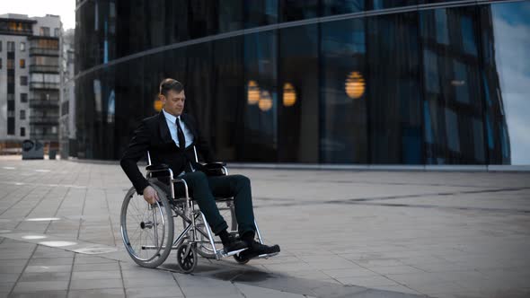 Disabled Businessman Rolling on Wheelchair Near Businesscentre