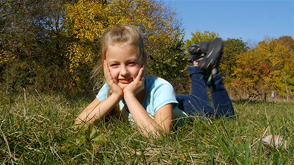 Happy Little Girl Lying On The Grass