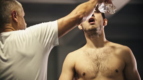 Box Training - a Tired Man Rinsing His Mouth and Spits in the Trash Can - a Trainer Helps Him