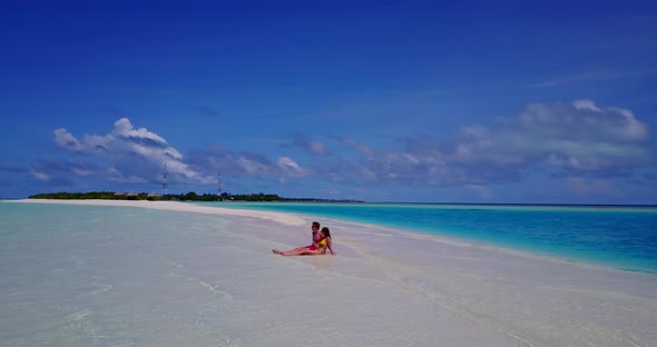 Beautiful man and woman on honeymoon vacation have fun on beach on paradise white sand 4K background