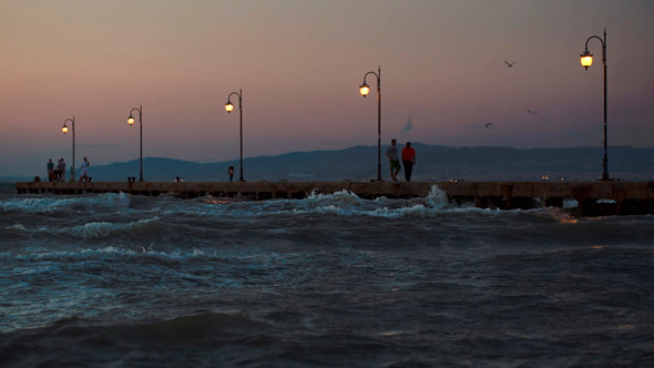 People On Pier In The Windy Evening