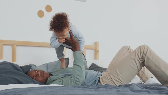 Happy Father Playing with Joyful Little Boy