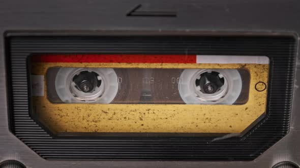 Vintage Yellow Audio Cassette Tape Rotates in Deck of an Old Tape Recorder