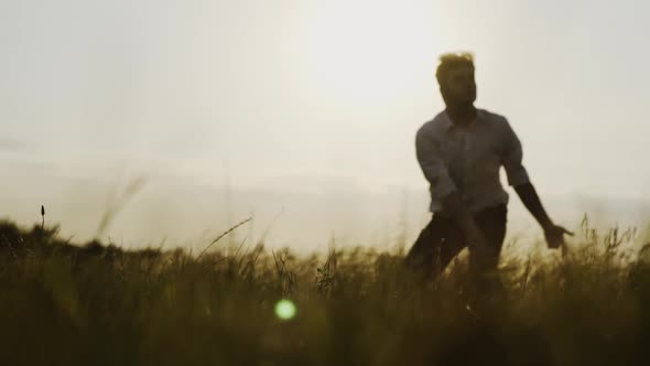 Slow motion shot of young man dancing outdoors against sun