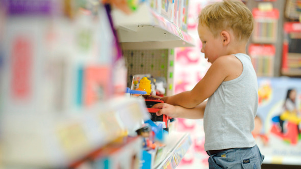 Boy Playing With Toy Car In The Shop