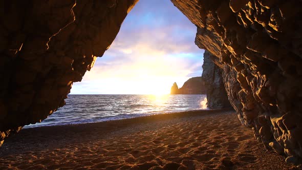 View From the Stone Cave on the Sunset Sea and the Beach the Volcanic Rock of the Cave is Lit By the