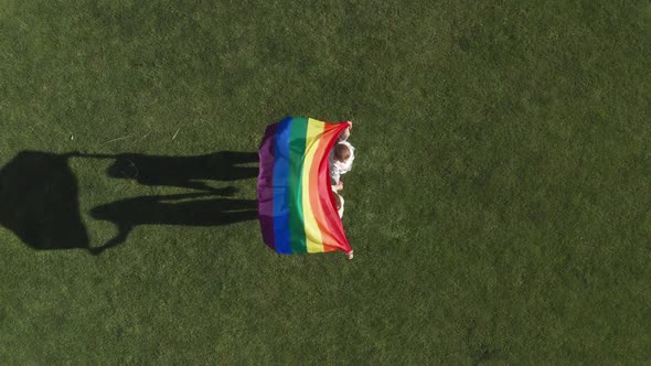 Drone Shot of Lgbt Flag Fluttering in Female Hands