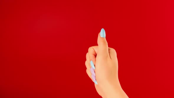 Woman's Hand with Beautiful Nails on Red Background