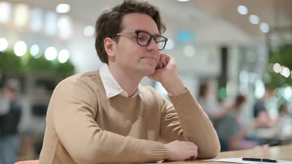 Young Male Designer Taking Nap in Office