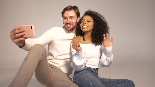 Smiling beautiful woman and her handsome boyfriend posing in studio