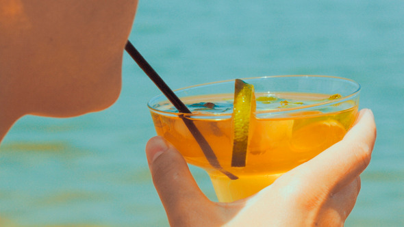 Woman Drinking Refreshing Cocktail With A Straw