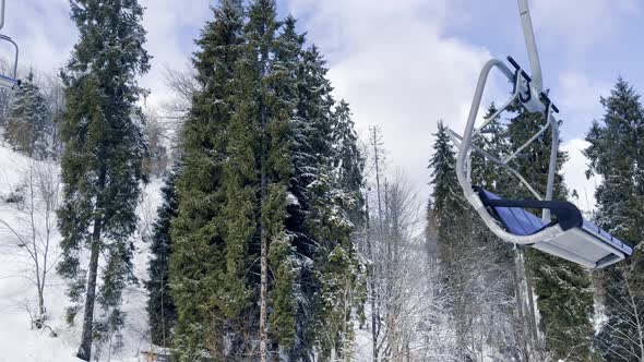 POV Empty Ski Lift Snowy Mountain Winter Forest with Chair Lift At The Ski Resort in Winter