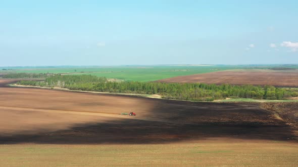 Aerial Flat View Tractor Plowing Field In Spring Season