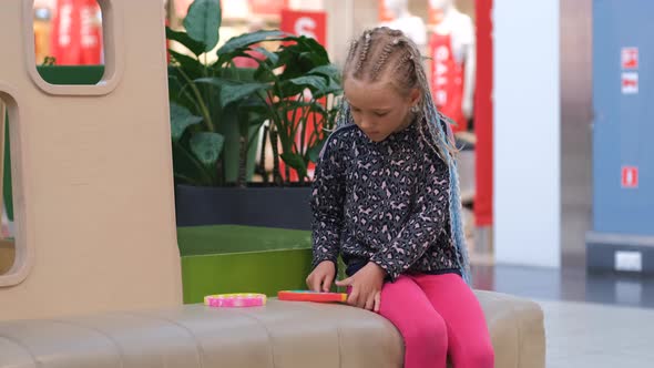 Girl Plays with Silicone Fidget Toys in Mall