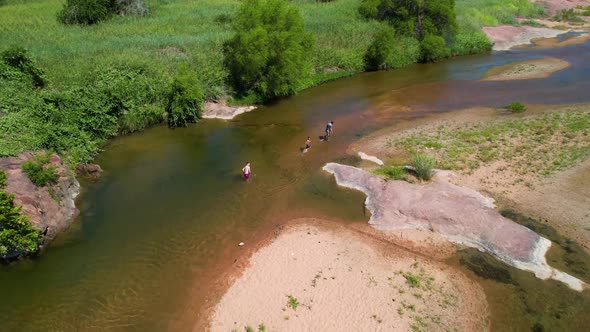 Aerial footage of the popular area on the Llano River in Texas called The Slab. People are walking i