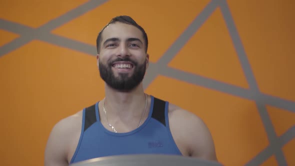 Portrait of Healthy Sportsman Jogging on Treadmill and Smiling