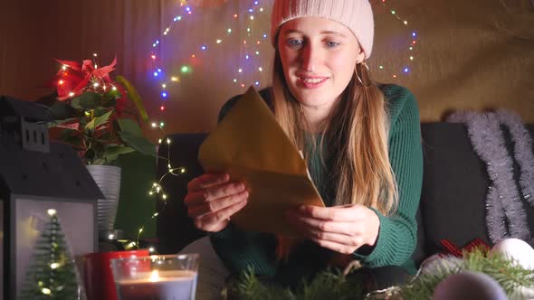Happy Young Woman Reading Christmas Greeting Card