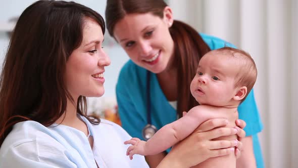 Doctor with a smiling mother holding a baby boy