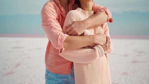 Camera Lifting Along Man and Woman Hugging and Tenderly Touching Each Other on White Desert or Beach