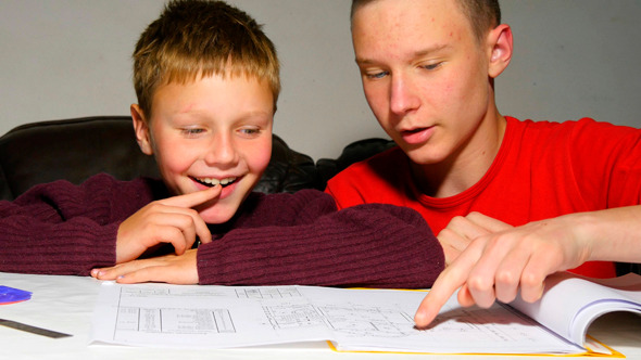 Teen Explaining Architectural Plan To His Brother