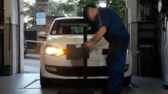 Car Repair Mechanic Adjusting Headlights
