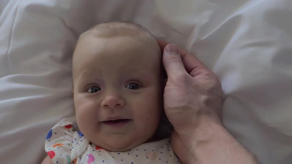 A Six Months Old Baby Girl Smiling To Father's Touch