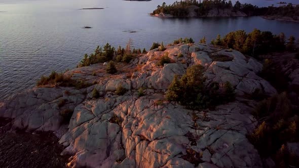 Small White Tent on Rocky Island in Blue Lake, Epic Drone Dolly Out Reveal, Aerial Wide Angle. Flyin