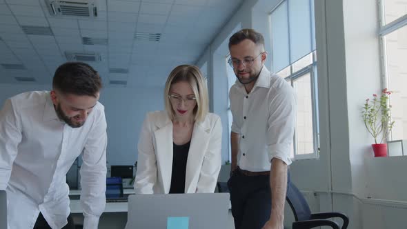 Coworkers Discuss Their Online Work on the Laptop