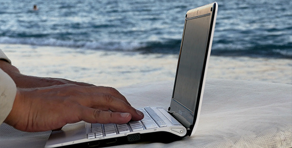 Working With Nootebook On The Beach