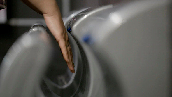 Woman Drying Hands In Special Machine alt