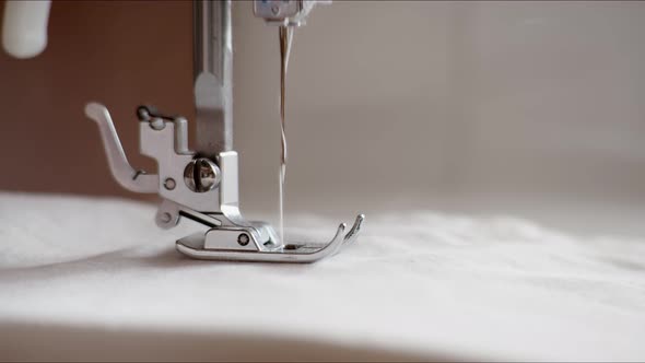 Sewing Machine Sews White Fabric with a Needle, Close Up Macro