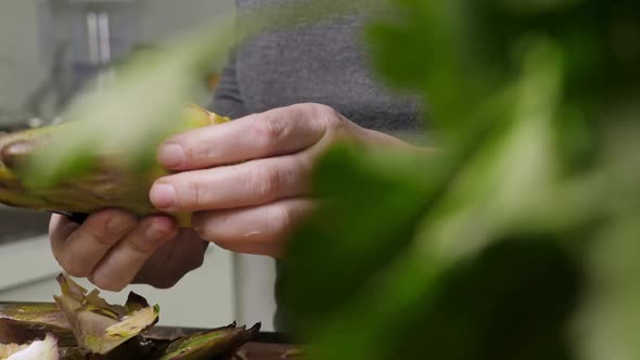 Woman Cleaning Artichokes with Knife