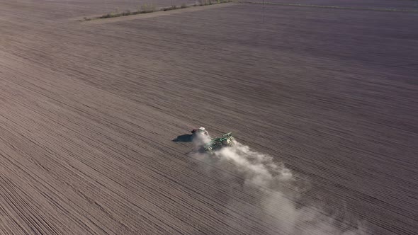 Aerial View of Farming Tractor Plowing a Field at Sunny Day