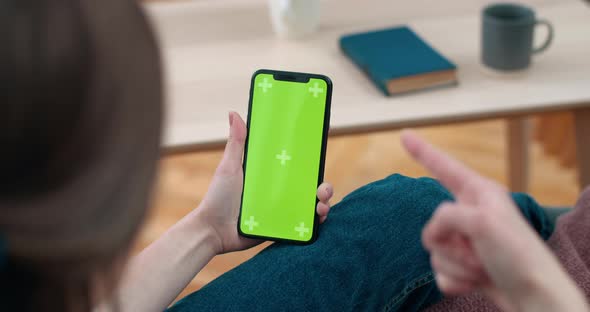 Backside View of Woman Holding and Looking at Smartphone Mock Up Screen. Female Person Waving and