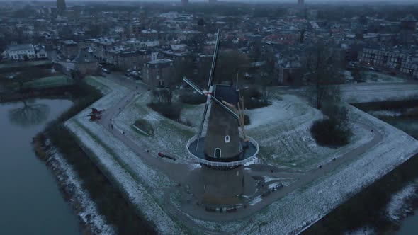 Mill At Bank Of Linge River With Town Buildings Of Gorinchem In Background During Winter In South Ho