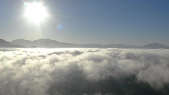 Aerial view of low fog over mountains in San Diego during sunrise