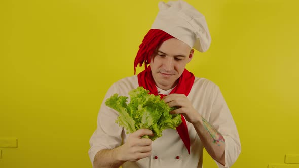Man with Red Dreadlocks Holds Lettuce Leaves