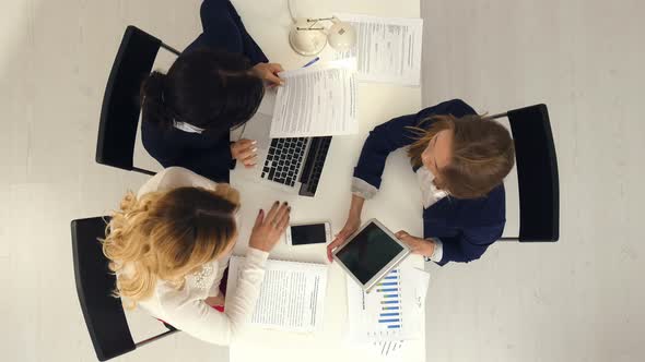 Three Business Women Working Together with Documets and Tablet Computer in the Office