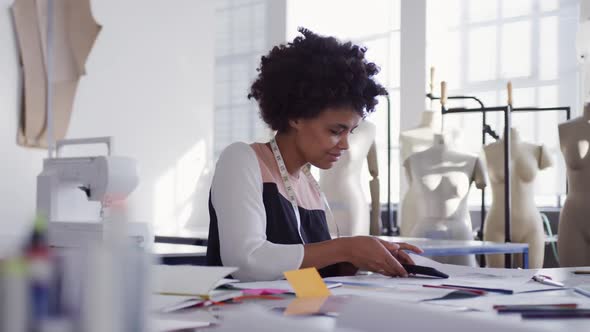 Mixed race woman on smartphone in fashion office